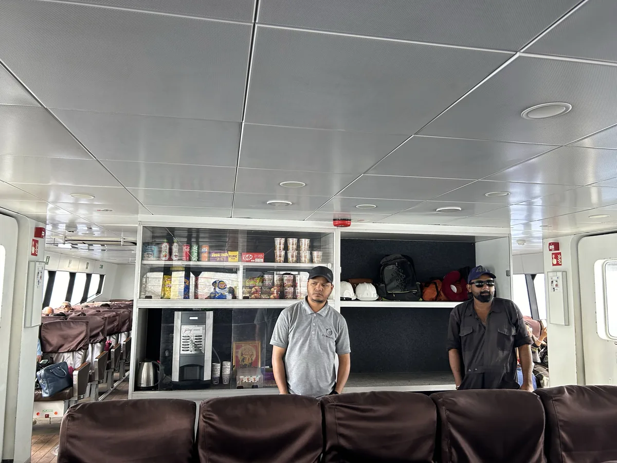 Crew at the onboard counter — ITT Majestic branding visible on the polo ITT Majestic crew at the onboard snack counter