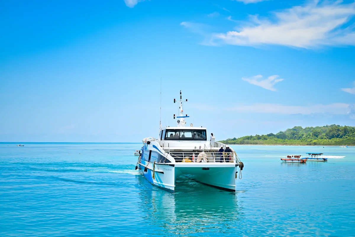 ITT Majestic underway — the twin-hull catamaran approaching an island stop ITT Majestic catamaran underway in turquoise Andaman waters