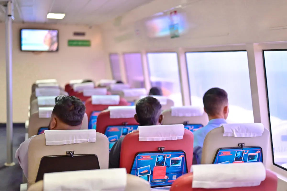 Premium class seating – airline-style AC seats with overhead luggage bins Makruzz ferry premium class interior with airline-style seating
