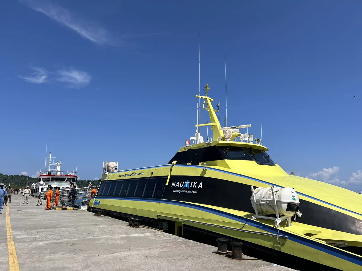 The Nautika livery at the jetty — gonautika.com painted along the hull Nautika catamaran hull with the operator's branding, docked at the jetty
